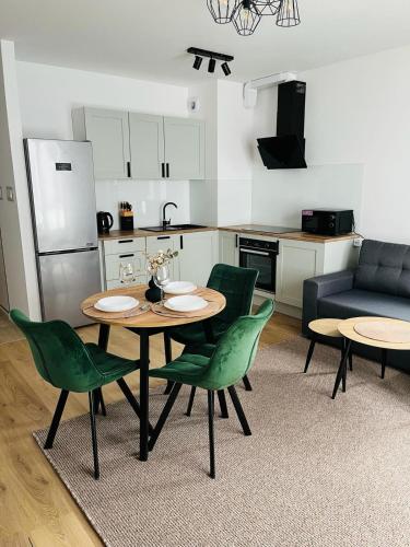 a living room with a table and chairs and a kitchen at MHL Apartament Lublin in Lublin