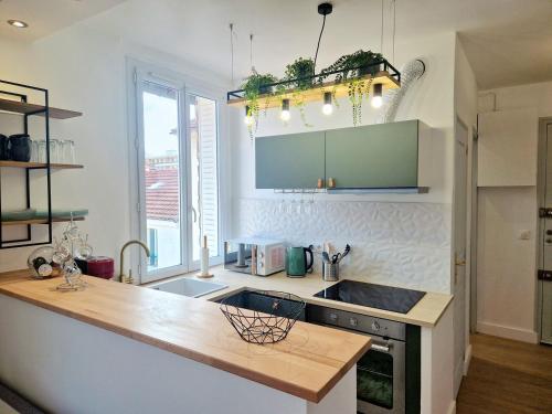 une cuisine avec un comptoir et un évier dans l'établissement L'Étape Pisciacaise / F2 4pers. de standing, à Poissy