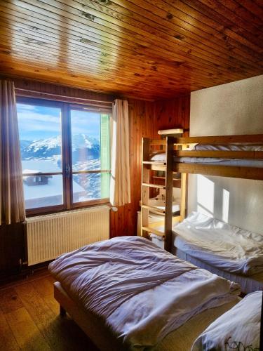 - une chambre avec 2 lits superposés et une grande fenêtre dans l'établissement Appartement skis aux pieds, à Peisey Vallandry, à Landry