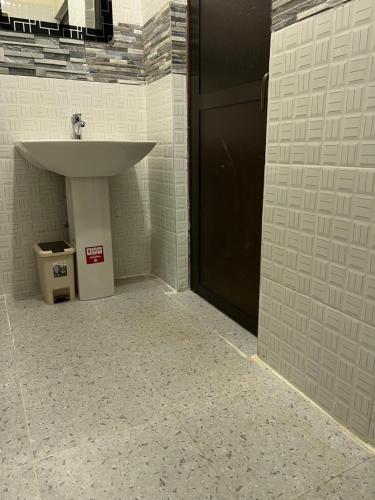 a bathroom with a sink and a trash can at Kilimanjaro Trekcity Hostel in Moshi
