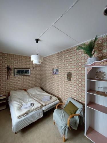 a bedroom with a bed and a chair in it at Private Room in Pink House in Pajala