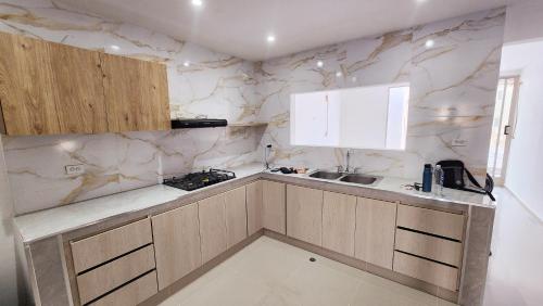 uma cozinha com paredes em mármore e uma bancada em Casa Hotel Hefziba em Barranquilla