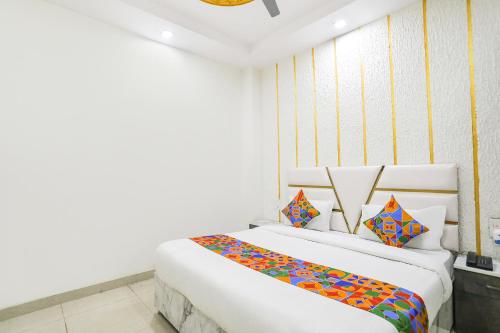 2 Betten in einem Zimmer mit weißen Wänden in der Unterkunft FabExpress Mahi Ganga Heritage in Haridwar