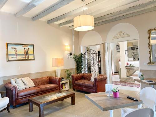 a living room with leather couches and a table at La Bergamina Hotel & Restaurant in Arcore