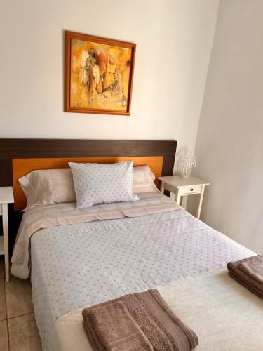 een slaapkamer met 2 bedden en een schilderij aan de muur bij Sueña en la Plaza Cervantes 3 in Alcalá de Henares