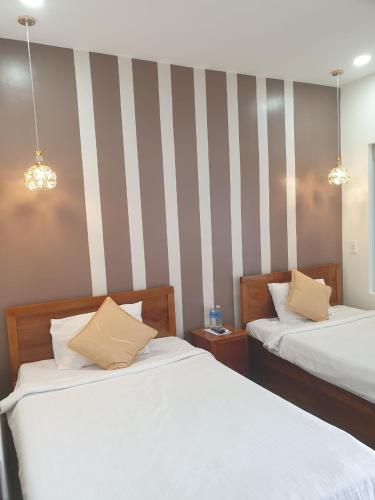 two beds in a room with striped walls at khách sạn Quốc Tế in Cà Mau