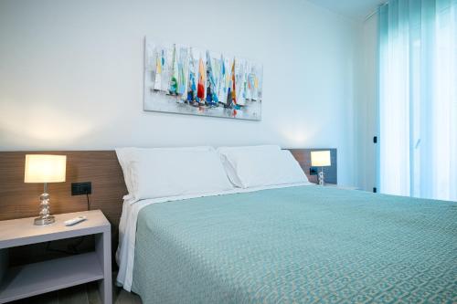 a bedroom with a large bed with a green bedspread at Milena Suite Apartments in Alghero