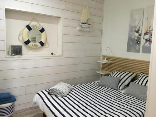 - une chambre avec un lit et une bouée de sauvetage sur le mur dans l'établissement Front de mer cap d'agde, au Cap d'Agde