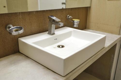 a white sink in a bathroom with a mirror at Hotel Sweet Home Near New Delhi Railway Station in New Delhi