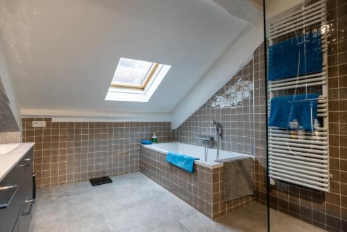 La salle de bains est pourvue d'une baignoire et d'une lucarne. dans l'établissement L'appartement du Cirque, à Paris