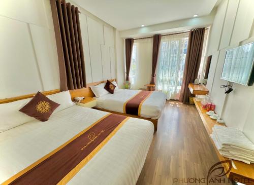 a hotel room with two beds and a television at Phuong Anh Hotel in Da Lat