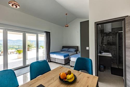 a room with a table and blue chairs and a bedroom at Villa Bella Draguc in Kurelići