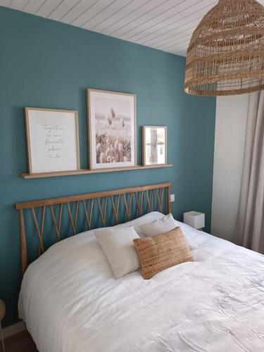 1 dormitorio con 1 cama con pared azul en Maison de centre-ville Ars en Ré, en Ars-en-Ré