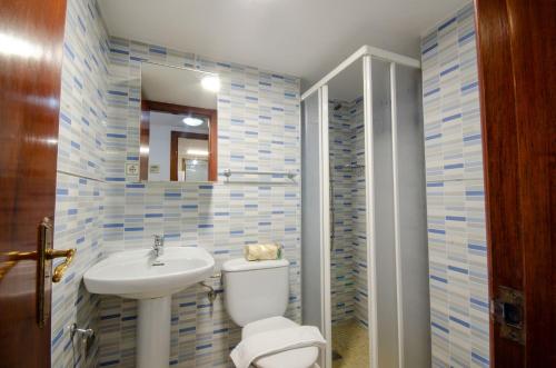 La salle de bains est pourvue de toilettes blanches et d'un lavabo. dans l'établissement GEMELOS 10 Levante Beach, à Benidorm