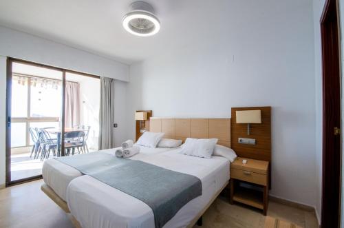 a bedroom with a large bed and a balcony at GEMELOS 10 Levante Beach in Benidorm