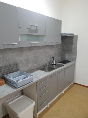 a kitchen with white cabinets and a sink at Ubytovna Moravan Brno in Brno