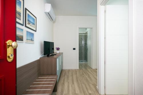 a living room with a television and a wooden table at Milena Suite Apartments in Alghero
