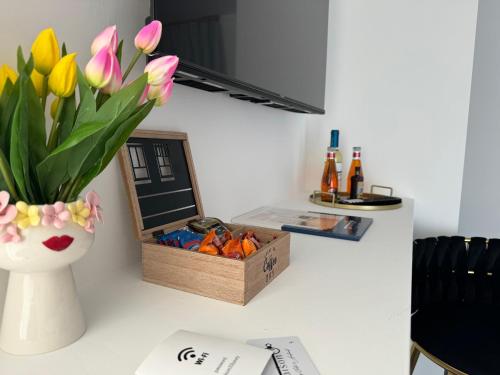 a desk with a vase of flowers and a box of pens at Maison 31 -Luxury Apartments in Santa Marinella