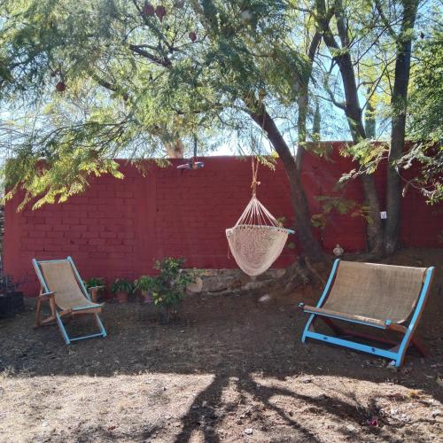 two chairs and a hammock under a tree at Casa de campo en Oaxaca in San Pablo Etla