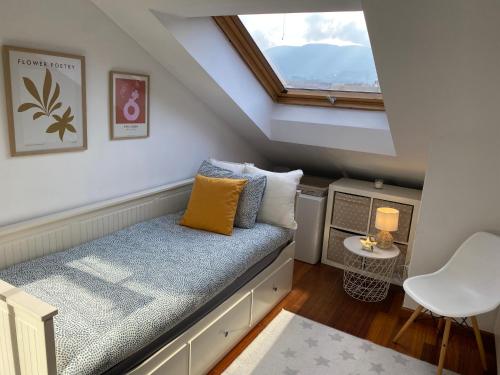 Dormitorio pequeño en el ático con cama y ventana en Acogedor atico en Ramallosa, en Pontevedra