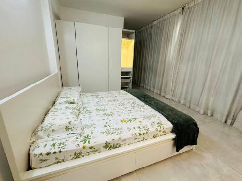 Dormitorio pequeño con cama con edredón de flores en White House Sky View Theatre Villa in Gachibowli en Hyderabad