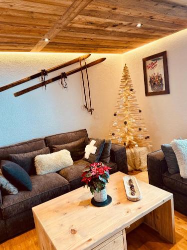 uma sala de estar com um sofá e uma árvore de Natal em 3,5 pces - 80m2- Villars-sur-Ollon em Ollon
