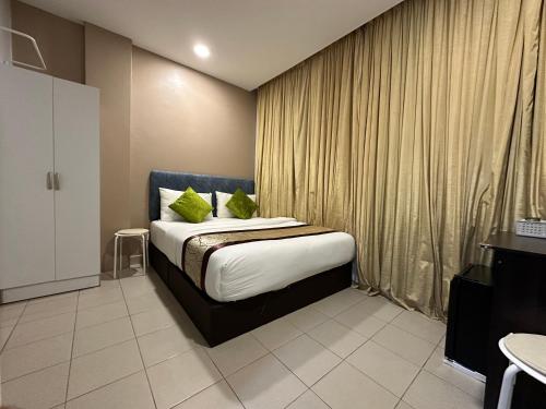een slaapkamer met een bed met groene kussens bij SS Grey Hotel in Kuala Lumpur