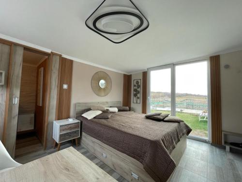 a bedroom with a large bed and a large window at Diamona Lux Spa Apartman in Niš