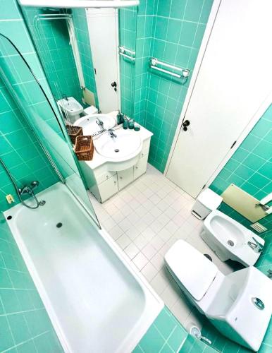 a bathroom with a tub and a sink and a toilet at Flat Luxuoso Praia da Oura in Albufeira