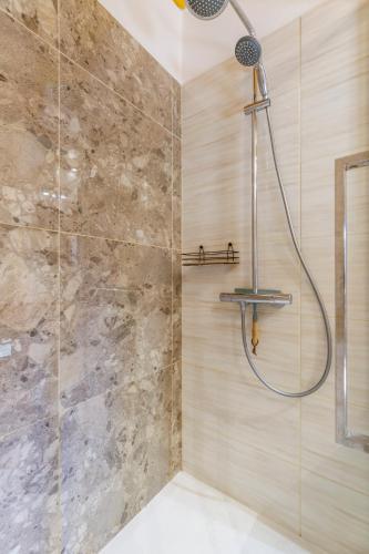 y baño con ducha y pared de piedra. en Chalupa 66 - Bukovka, en Červená Voda