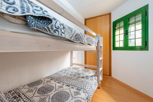 two bunk beds in a room with a window at Bettatur Apartament Ripoll in Tarragona