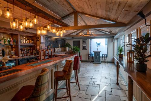 a bar with a counter and chairs in a room at Crab & Boar in Newbury