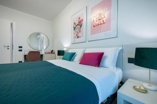 a bedroom with a blue and white bed and a table at Milena Suite Apartments in Alghero