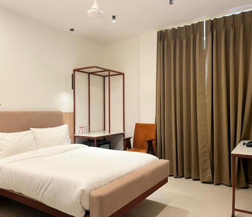 a bedroom with a bed and a large window at HOTEL VARUNA Varanasi in Varanasi