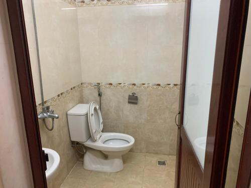 a small bathroom with a toilet and a sink at Nhà Nghỉ Hải Nam in Dien Bien Phu