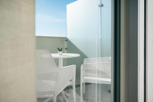 a room with two chairs and a table and a table at Milena Suite Apartments in Alghero