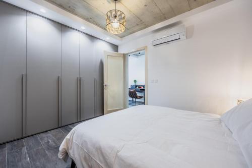 1 dormitorio con cama blanca y escritorio en Brand new home close to all amenities. An exceptionally chic get-away!, en Taʼ Xbiex