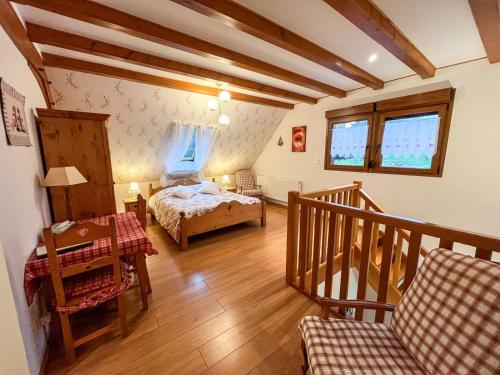 Un pequeño dormitorio con una cama y una escalera en Le Charme de l'Altenberg, en Neubois