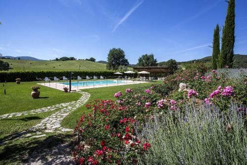 un jardín con flores y una piscina en Agriturismo I Granai, en Crocemaroggia
