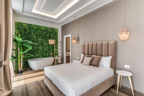a bedroom with a white bed and a bath tub and a tub at ATAROOMS Suites Napoli in Naples