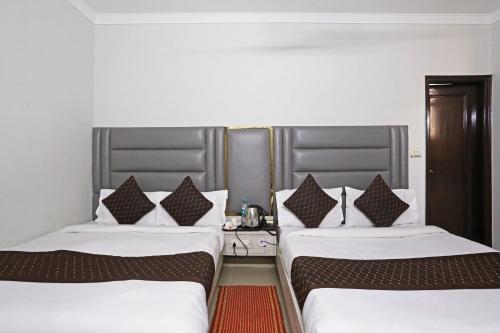 two beds sitting next to each other in a room at Ratandeep International in New Delhi