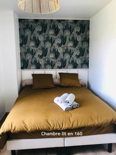 a bed with two towels sitting on top of it at Gîte du Pescadou, 4 personnes, jacuzzi, wifi et netflix in Tournon-dʼAgenais