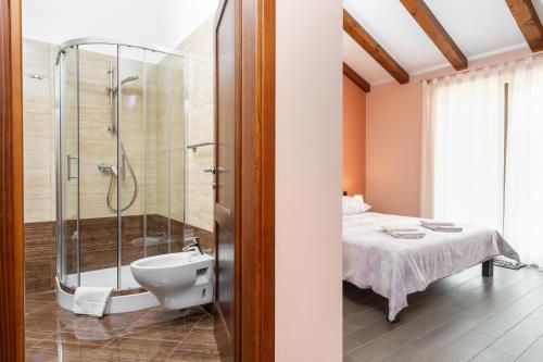 ein Bad mit einer Dusche, einem Bett und einem Waschbecken in der Unterkunft Villa Genia II in Poreč