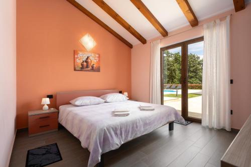 ein Schlafzimmer mit einem Bett und einem großen Fenster in der Unterkunft Villa Genia II in Poreč