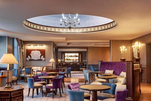 a hotel lobby with tables and chairs and a chandelier at Disneyland® Hotel in Chessy