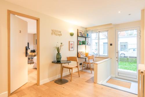une cuisine et une salle à manger avec une table et des chaises dans l'établissement Maison Letellier, à Paris