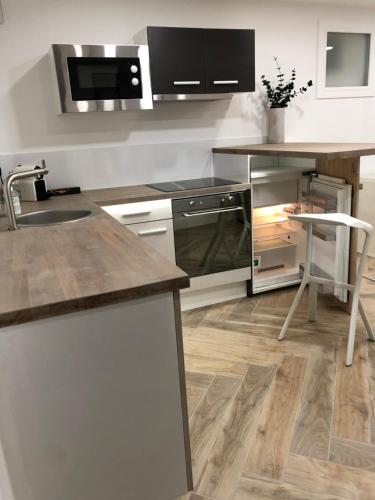 une cuisine avec un évier et un plan de travail dans l'établissement Cosy Studio, à Colombes