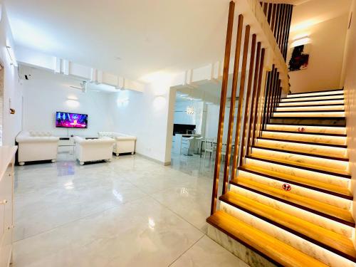 a lobby with a staircase and a living room at White House Sky View Theatre Villa in Gachibowli in Hyderabad