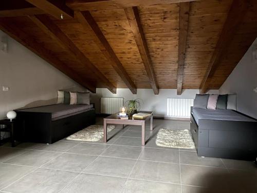 a living room with two beds and a table at Sém chì, relaxing cottage in the mountains in Gromo