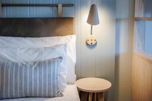 a bedroom with a bed with a table and a lamp at Quality Hotel Skjærgården in Langesund